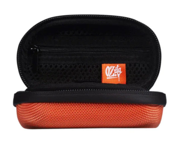 Estuche pequeño rígido color naranja con cremallera, interior negro y etiqueta Ozeta